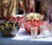 Catering buffet table with serving bowls, champagne flutes and pots of cocktail sticks